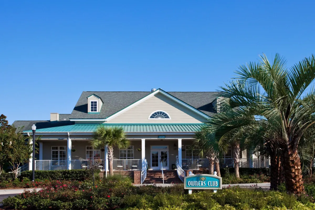 The main resort entrance is framed by lush landscaping and clear signage, giving a sense of organization and easy navigation. The entrance is inviting, with a clean roofline and welcoming communal areas.